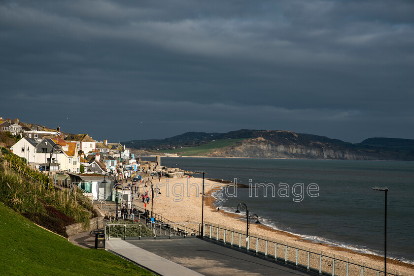 lyme-046 
 Lyme Regis and Uplyme riverside walk 
 Keywords: Lyme Regis, Uplyme, coastal town, Devon, Dorset, boarder, riverwalk, seaside, sea view, gardens, beach, sea, cliffs, seatown, clouds, dark clouds, sunshine, spring